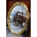 Large oval gold beveled mirror with floral design