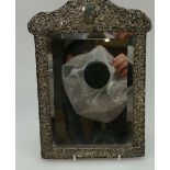 A ladies dressing table mirror with ornate silver frame ,