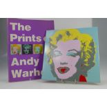 A catalogue "The Prints of Andy Warhol" and large tile decorated with the Marilyn Monroe Warhol