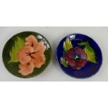 Moorcroft round dish decorated in the pansy design and a similar one in the Hibiscus design,