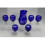 A collection of blue cut glass items to include water jug,