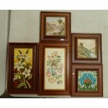 A collection of 5 framed decorative ceramic tiles.