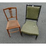 A black painted Edwardian nursing chair in green upholstery on casters with an inlaid Art Nouveau