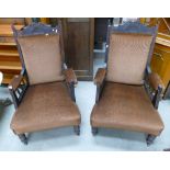 A pair of Edwardian parlour chairs on turned legs and castors with brown upholstery. (2)