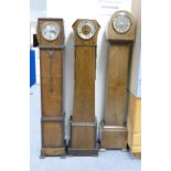 A set of three oak cased Art Deco Granddaughter long cased clocks. (3)