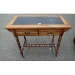 A Satin wood writing desk with two drawers on turned legs with casters.