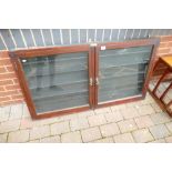 A wall hanging, two door glazed fronted display cabinet with shelving.