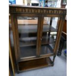 Oak display cabinet with glazed front, sides and back on open shelved legs.