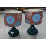 A pair of modern ceramic table lamps with floral shades in a Burgundy and blue design.