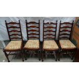 A set of four reproduction oak ladder backed dining chairs with floral upholstered seats.