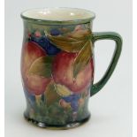 William Moorcroft Burslem tankard decorated in the Pomegranate design on ochre ground,