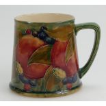 William Moorcroft Burslem tankard decorated in the Pomegranate design on ochre ground,