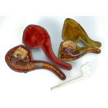 A meerschum pipe carved as a woman's head and hat and another carved pipe,