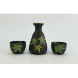 Wedgwood black basalt sake set comprising bottle and two bowls decorated with gilded green leaves