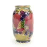 William Moorcroft miniature vase decorated in the Pomegranate design on light green ground,