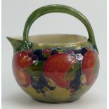 William Moorcroft Burslem milk jug decorated in the Pomegranate design on ochre ground, height 12.