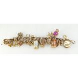 Heavy 9ct gold charm bracelet and quantity of gold charms. 61.4 grams gross.