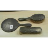 Three piece silver backed dressing table set comprising hand mirror, hair brush and clothes brush