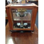 A set of Stanton laboratory scales, model A.D.I in a stained glazed case, raised on adjustable feet,