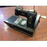 An English made Vulcan miniature sewing machine, the black enamelled tinplate body with gilt