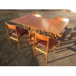 A 70s teak dining table & chair set, the chairs with shaped backs above padded upholstered seats,