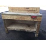 A rectangular workbench with upstand, vice, and open shelf raised on column legs.