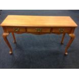 A Georgian style oak sideboard with rectangular moulded top above three frieze drawers mounted