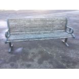 A cast iron bench, with hardwood slatted back and seat mounted on scrolled angle iron ends.