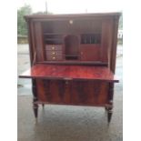 A mahogany escretoire, the rounded top above a fallfront enclosing an interior with drawers,