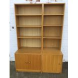 A pair of oak open bookcases, each with three adjustable shelves above cupboards mounted with knobs.