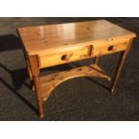 A pine side table with rectangular moulded top above two frieze drawers, raised on turned legs