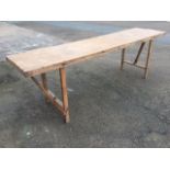 Five 8ft rectangular trestle style tables, supported on folding legs. (5)