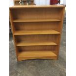 A Herbert Gibbs open bookcase with adjustable shelves above an arched apron.