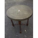 A circular brass topped occasional table, the tray top decorated with eastern motifs raised on