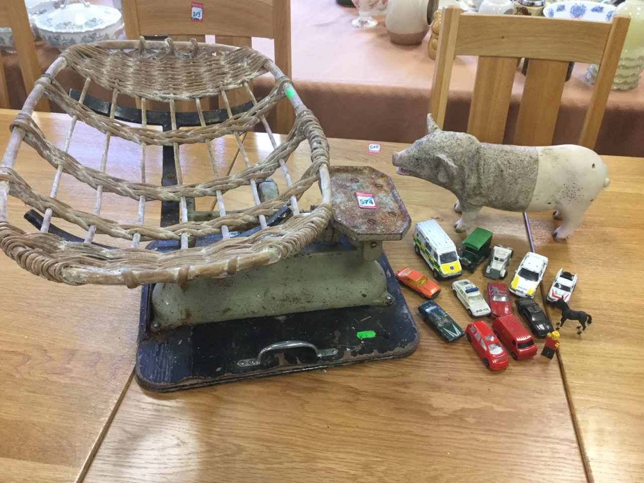 A set of weighing scales with cane basket; a snorting pig; and 12 toy cars - Matchbox, Corgi, etc