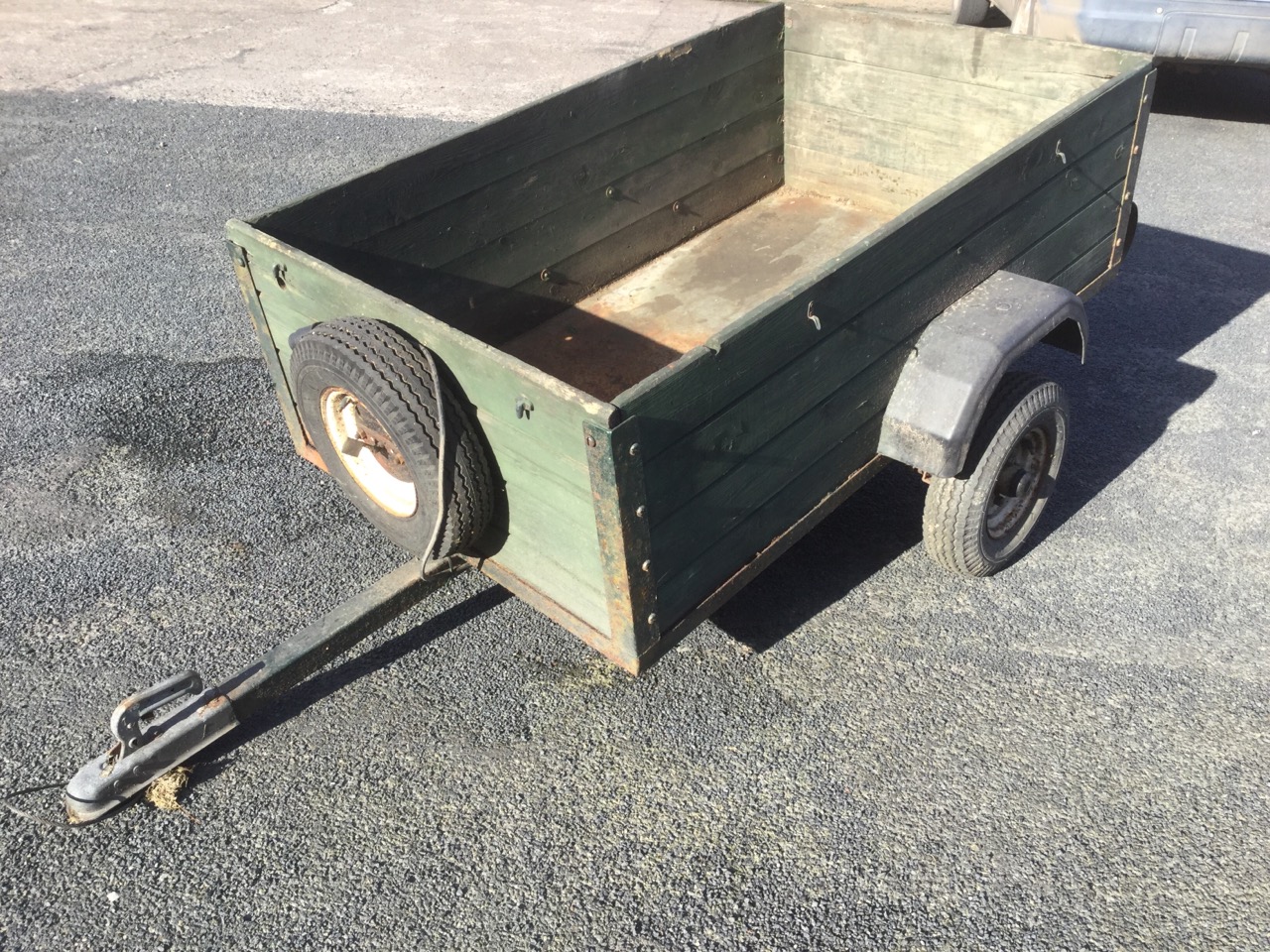 A 5ft wood trailer with boarded sides on single axel, complete with spare wheel and electric hook up