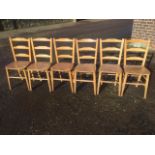 A set of six elm ladderback dining chairs, with shaped solid seats supported on turned legs and