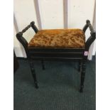 An Edwardian ebonised piano stool with ring-turned handles and legs, the rectangular hinged lid