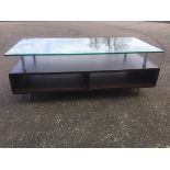 A contemporary coffee table, with rectangular plate glass top supported on tubular columns, above