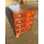 A dwarf mahogany bowfronted chest of four drawers mounted with ring handles, raised on bracket