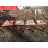 A set of four mahogany Chippendale style dining chairs with pieced carved splats above tapestry