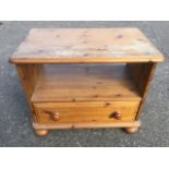 A pine bedside cabinet with rectangular moulded top above an open compartment & drawer,