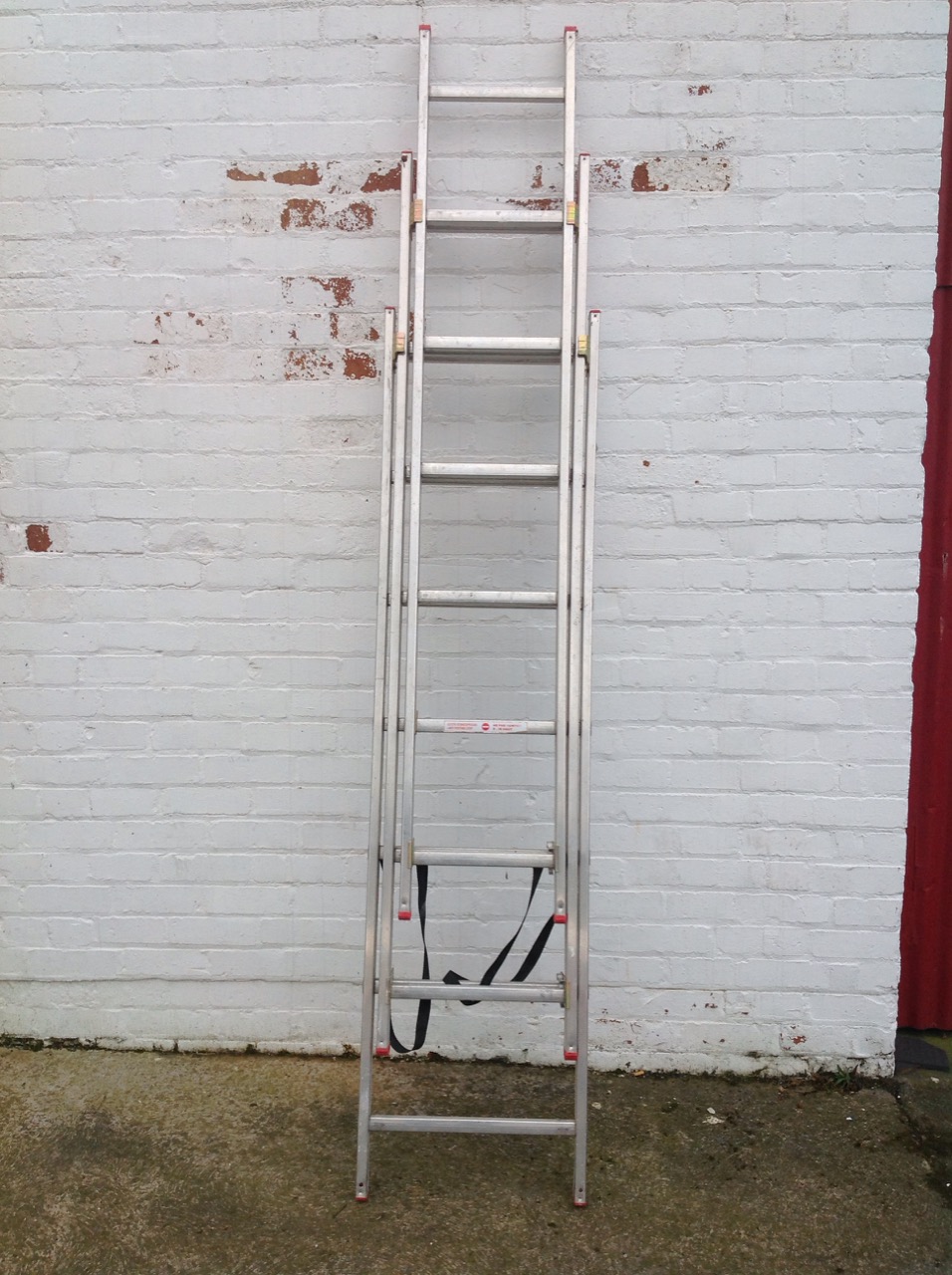 A Starlight triple extension aluminium ladder, with ribbed rungs, straps, etc.