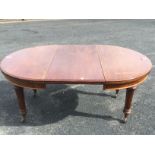 A Victorian walnut dining table with telescopic action and spare leaf