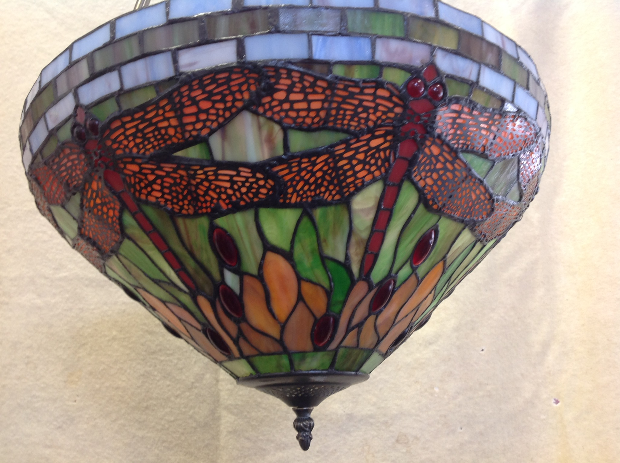 A tiffany style hanging light with leaded glass shade in the dragonfly pattern,