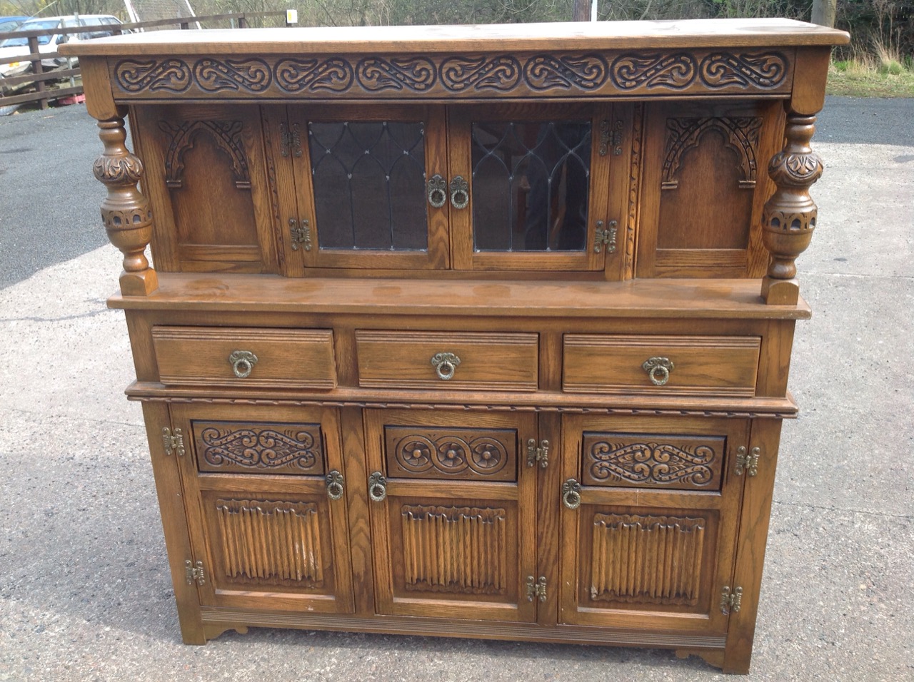 A carved oak cupboard with leaded glass doors