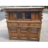 A carved oak cupboard with leaded glass doors