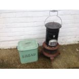 A rectangular green enamelled breadbin & cover and a tubular enamelled Valor stove with swing handle