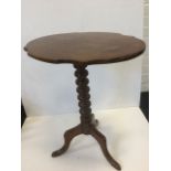 A Victorian mahogany occasional table with oval scalloped top on a bobbin turned column