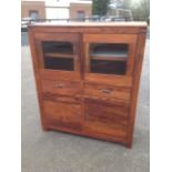 A contemporary hardwood cabinet with glazed doors above two drawers, having cupboards below.